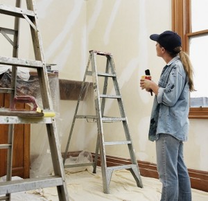 Home renovating, woman mid-thirties having a cup of tea during room painting